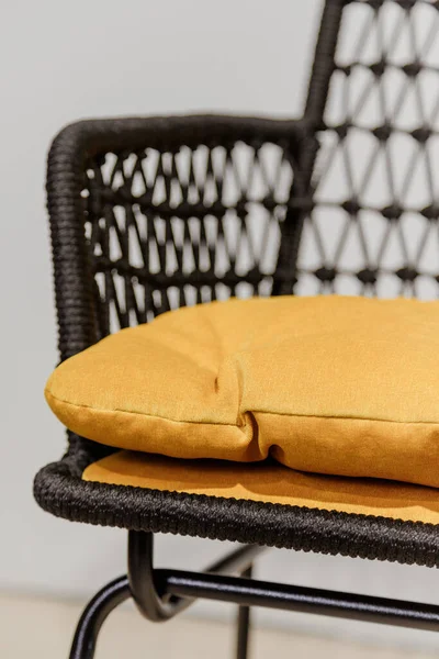 Μαύρη ψάθινη καρέκλα με κίτρινα μαξιλάρια. Λεπτομέρειες — Φωτογραφία Αρχείου