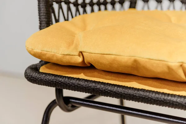 Black wicker chair with yellow pillows. Details — Stock Photo, Image