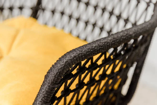 Fekete fonott szék sárga párnákkal. Részlet — Stock Fotó