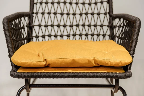 Chaise en osier noir avec oreillers jaunes. Détails — Photo