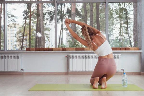 Yoga mujer vista posterior meditar sentado en pose de loto sobre grandes ventanas de fondo. Vista trasera — Foto de Stock