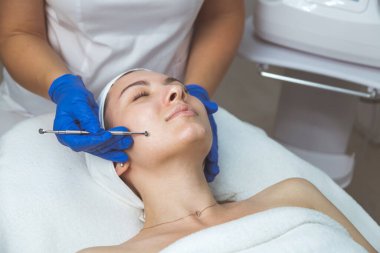 Güzellik uzmanı, temizleyici yüz ve gözenekleri temizlemek için çoklu delik kaşığı kullanıyor..