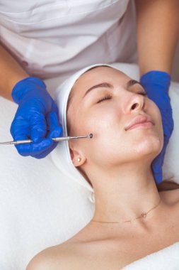 Güzellik uzmanı, temizleyici yüz ve gözenekleri temizlemek için çoklu delik kaşığı kullanıyor..