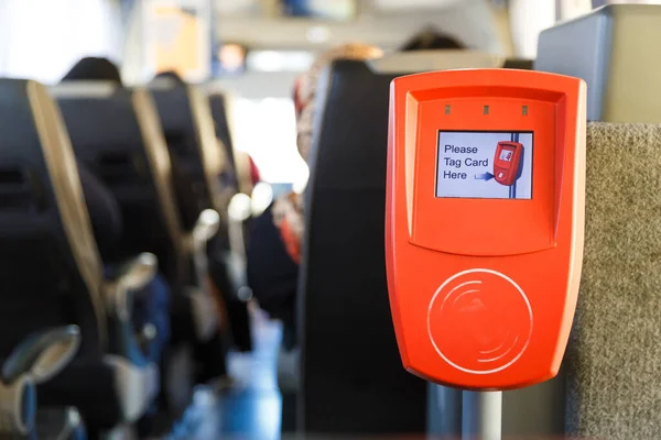 Πορτοκαλί μηχανή επικύρωσης εισιτηρίων σε ένα σύγχρονο λεωφορείο δημόσιων μεταφορών — Φωτογραφία Αρχείου