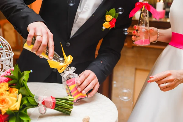 sand ceremony being performed at wedding. Brides hands holding vase with colorful sand during wedding party