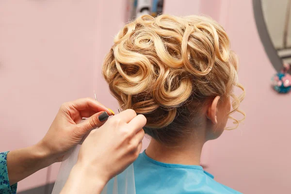 Hands of the hairdresser doing celebratory stacking of hair to the bride — Stock Photo, Image