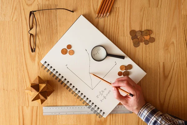 Economista trabalhando em uma mesa de madeira — Fotografia de Stock