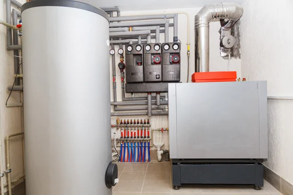 A domestic household boiler room with a new modern heating oil warm water system and pipes — Stock Image A domestic household boiler room with a new modern heating oil warm water system and pipes Stock Photo