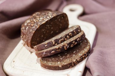 Ahşap tahta üzerinde karanlık ekmek kırıntıları ile dilimlenmiş