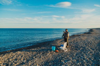 Denizde güneşli bir günde balık tutan adam 