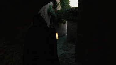 Koyu renk elbiseli bir adam ve yürüyen ve arayan bir fener. 