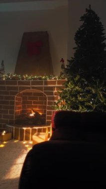 Süslü Noel ağacı ve tuğla şömine bir sürü hediye kutusu ve tüylü bir kilimin üzerinde parlayan peri ışıklarıyla çevrili..