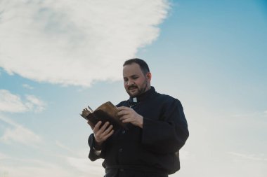 Güneşli bir günde doğada dua eden bir rahip.