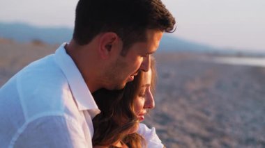 Bir çift gün batımında bebek paylaşımı bekliyor..