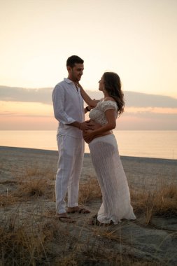 Bir çift gün batımında bebek paylaşımı bekliyor..