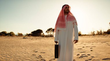 Şeyh elinde para çantasıyla çölde bekliyor. .