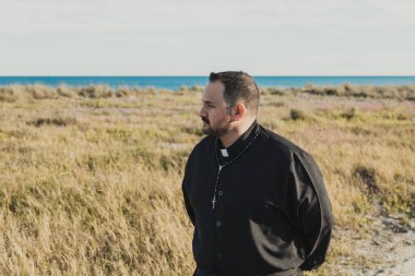 Güneşli bir günde doğada dua eden bir rahip.