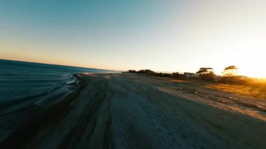 Kıyı şeridinde günbatımına bakan uçuş .