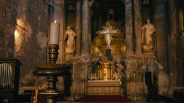 Sunaktaki kutsal haçın önündeki bir mum ışığı..