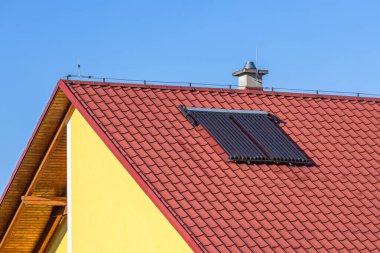 Bir aile evinin eğimli kırmızı çatısına yerleştirilmiş vakum tüpü koleksiyoncusu..