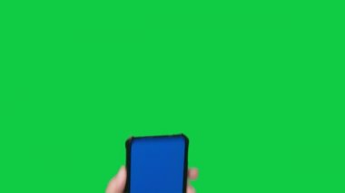 Kadın el ele tutuşup ekrana dokunuyor. Krom anahtar yeşil ekran arka planda mavi ekranlı akıllı telefon..