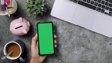 Üst görünüm, müşteri elleri kredi kartı ve akıllı telefon ile krom anahtar yeşil ekran ekranı, online ödeme konsepti.