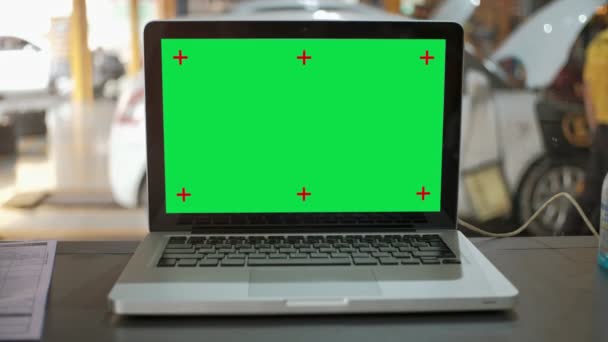 ガレージショップの机のテーブルの上の緑の画面のラップトップコンピュータ — ストック動画