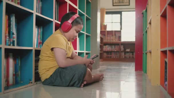 Evde Akıllı Telefon Kullanan Kırmızı Kulaklıklı Asyalı Küçük Çocuk — Stok video