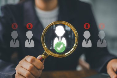 İş kadını başvuranlar arasında başarılı bir aday seçmek için büyüteç kullanıyor, işe alım ve işe alım simgesi olarak.