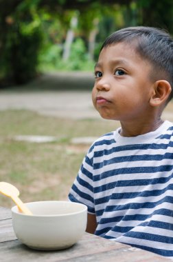 Asyalı çocuk kahvaltı için bekliyor.