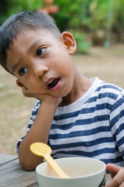 Asyalı çocuk kahvaltı için bekliyor.