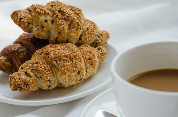 Sesam-Croissant und heißer Kaffee zum Frühstück. — Stockfoto