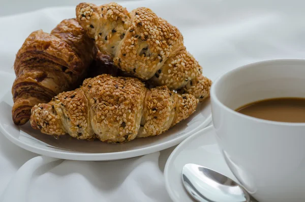 Sesam-Croissant und heißer Kaffee zum Frühstück. — Stockfoto