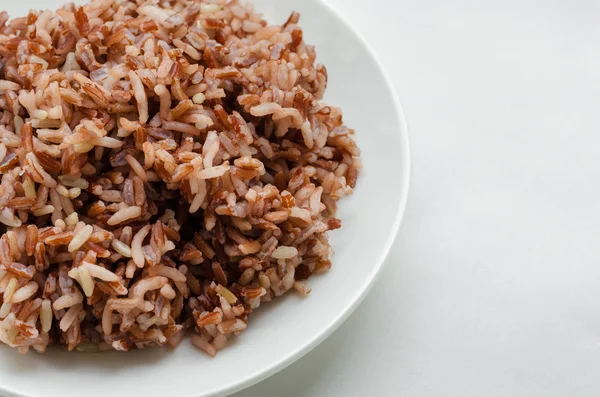 Бурый рис на белой тарелке . — стоковое фото