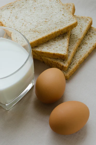 Geschnittenes Vollkornbrot, gekochtes Ei und Milch zum Frühstück. — Stockfoto