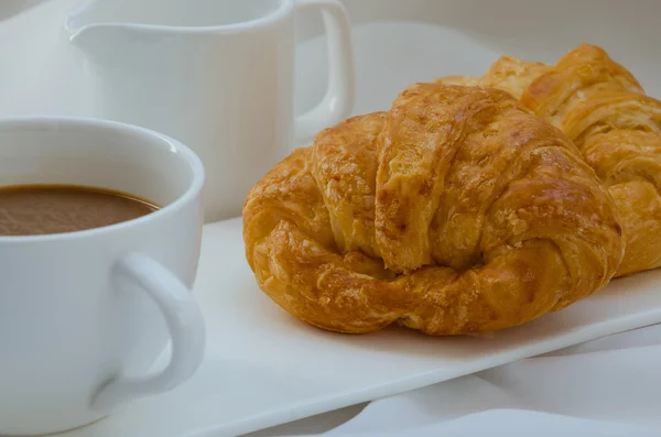 Croissant a kafe k snídani. — Stock fotografie