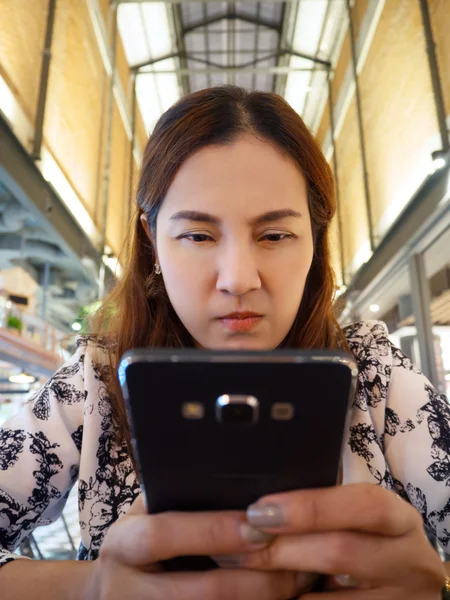 Asyalı kadınlar cep telefonu ve öfkeli bak.