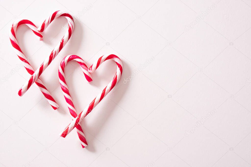 hearts lined with striped christmas lollipops on the right side of the background