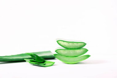 Aloe Vera 'nın üç sulu parçası beyaz arka planda üst üste yatar.