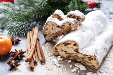 Badem ezmeli noel pastası, parşömen kağıdında fındık ve kuru üzüm, tarçın ve anason, dokulu arka planda köknar dalları