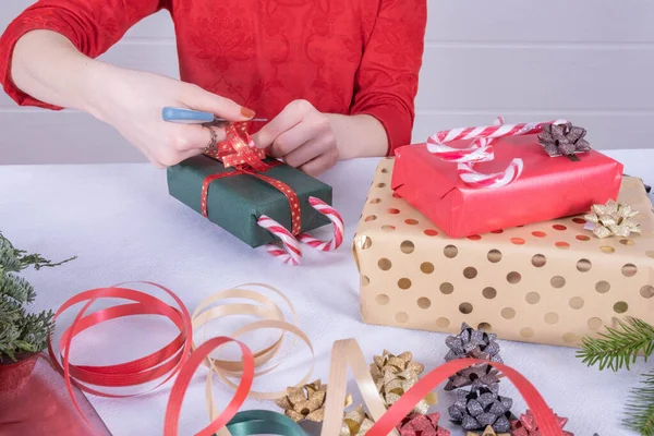 Дівчина Прикрашає Різдвяні Подарунки Стрічками Цукерками Вже Загорнуті Подарунки Лежать — стокове фото