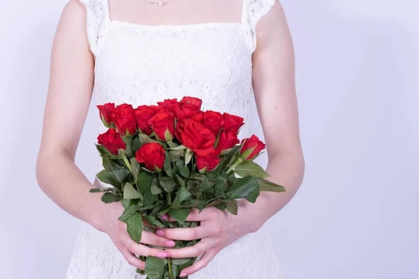 Uma Jovem Vestido Branco Segurando Buquê Rosas Vermelhas Fundo Branco — Fotografia de Stock