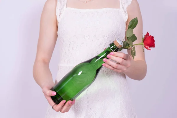 Menina Vestido Branco Segura Uma Garrafa Champanhe Uma Rosa Vermelha — Fotografia de Stock