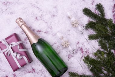 Şekerler, bir hediye, şampanya ve şarap kadehleri karlı bir arkaplanda 