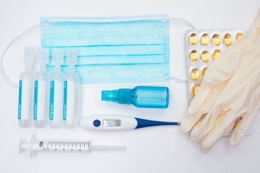 Lateks eldivenler, taştan yapılmış kırmızı kalp, vitaminler, termometre, iğneler için su, beyaz arka planda bir şırınga.