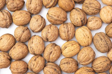 Cevizler beyaz arka planda masanın üzerine saçılmış.