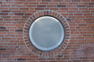 Tuğla bir duvarda, dışarıda demir ızgara var.