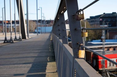 Demiryolu köprüsündeki kablolardan çeşitli kilitler sarkıyor.