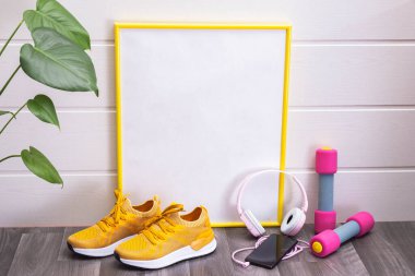 Evde egzersiz - dambıllar ve sarı spor ayakkabılar, işaret, sarı çerçeveli, notlar, kulaklıklar ve bir cep telefonu için, hepsi beyaz arka planda.