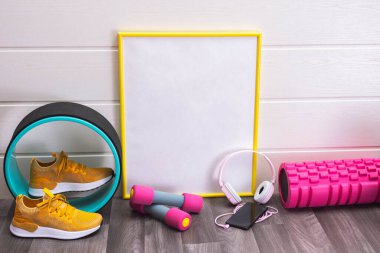 Sarı spor ayakkabılar, masaj ruloları ve halterler, plaka, sarı çerçeveli, notlar, kulaklıklar ve beyaz arka planda bal peteği için